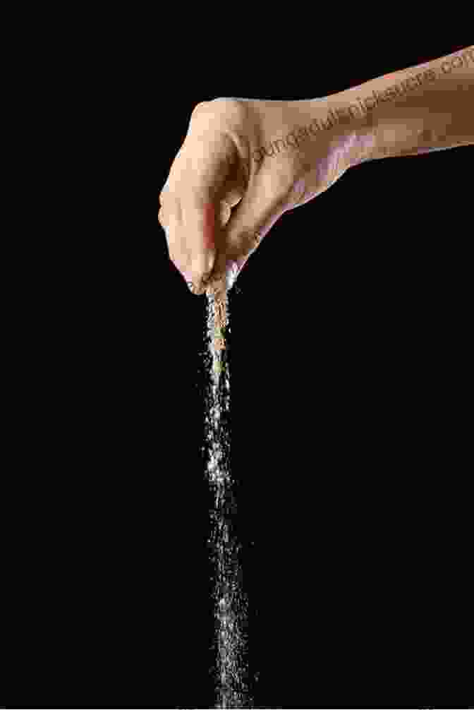 A Child's Hand Sprinkling Black Pepper Over A Dish Of Water, Creating A Mesmerizing Effect As The Pepper Particles Are Repelled By The Soap. Top 21 Science Experiments For Kids: Learn Engage And Have Fun With These Great Science Projects For Children In Elementary And Junior High